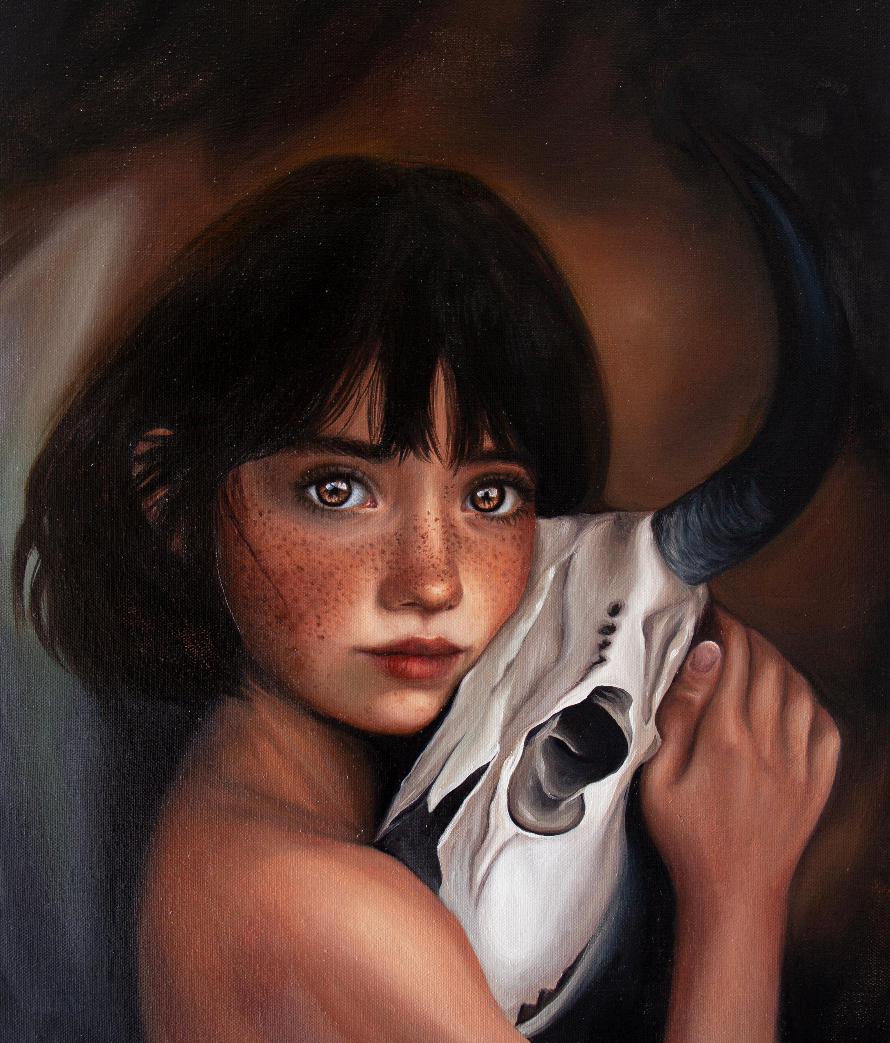 A painted portrait of a young girl with dark hair and freckles holding a white horned skull against a dark brown and black background. Acrylic painting by Kareen Kalush